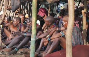 young hamar men in traditional dress observe the bull jumping ritual